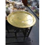 EASTERN BRASS TRAY TOP FOLDING TABLE WITH INCISED SCRIPT AND ARABESQUES, 23in (58.5cm) diameter