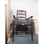 AN ANTIQUE OAK LADDER BACK OPEN ARMCHAIR WITH RUSH SEAT