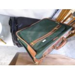 A GREEN CANVAS AND LEATHER MOUNTED SUITCASE, 22” WIDE AND A GENT’S BLACK LEATHER FOLD-OVER SUIT