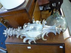 A SILVERED, SCROLL CARVED WOOD WALL BRACKET, WITH MIRROR AND CANDLE LAMP, WITH INVERTED CAMPANA