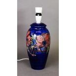 Moorcroft pottery tall ovular vase table lamp, with large red flowers on a royal blue ground,