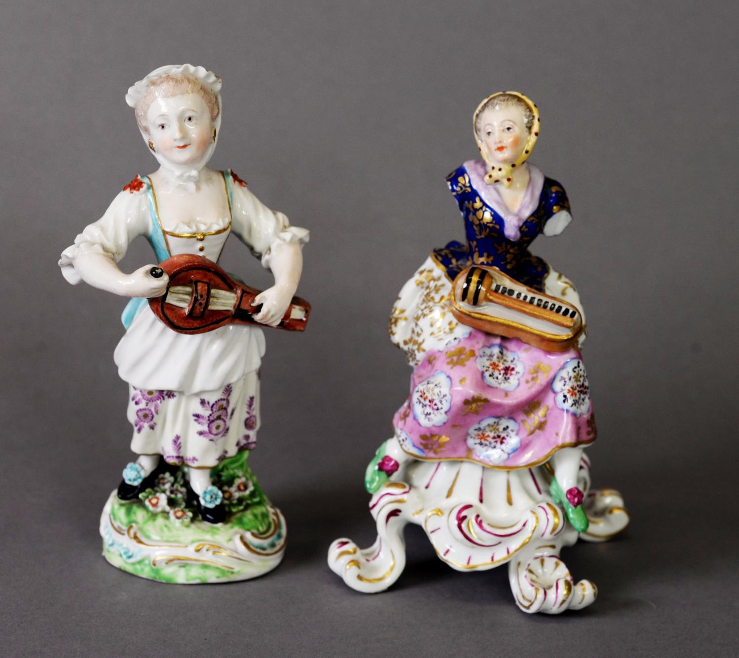 19TH CENTURY DERBY FIGURE GROUP OF A WOMAN IN HEADSCARF WITH A HURDY-GURDY, on scrolling