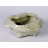 CHINESE PALE CELADON CRACKLE GLAZED PORCELAIN BOWL OF IRREGULAR FORM, raised on four stud feet,