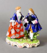 19TH CENTURY FIGURE GROUP OF A LADY AND GENTLEMAN IN 18TH CENTURY DRESS, he with tricorn hat, red