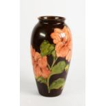 WALTER MOORCROFT LIMITED EDITION HIBISCUS PATTERN TUBE LINED POTTERY VASE WITH A BROWN GROUND, of
