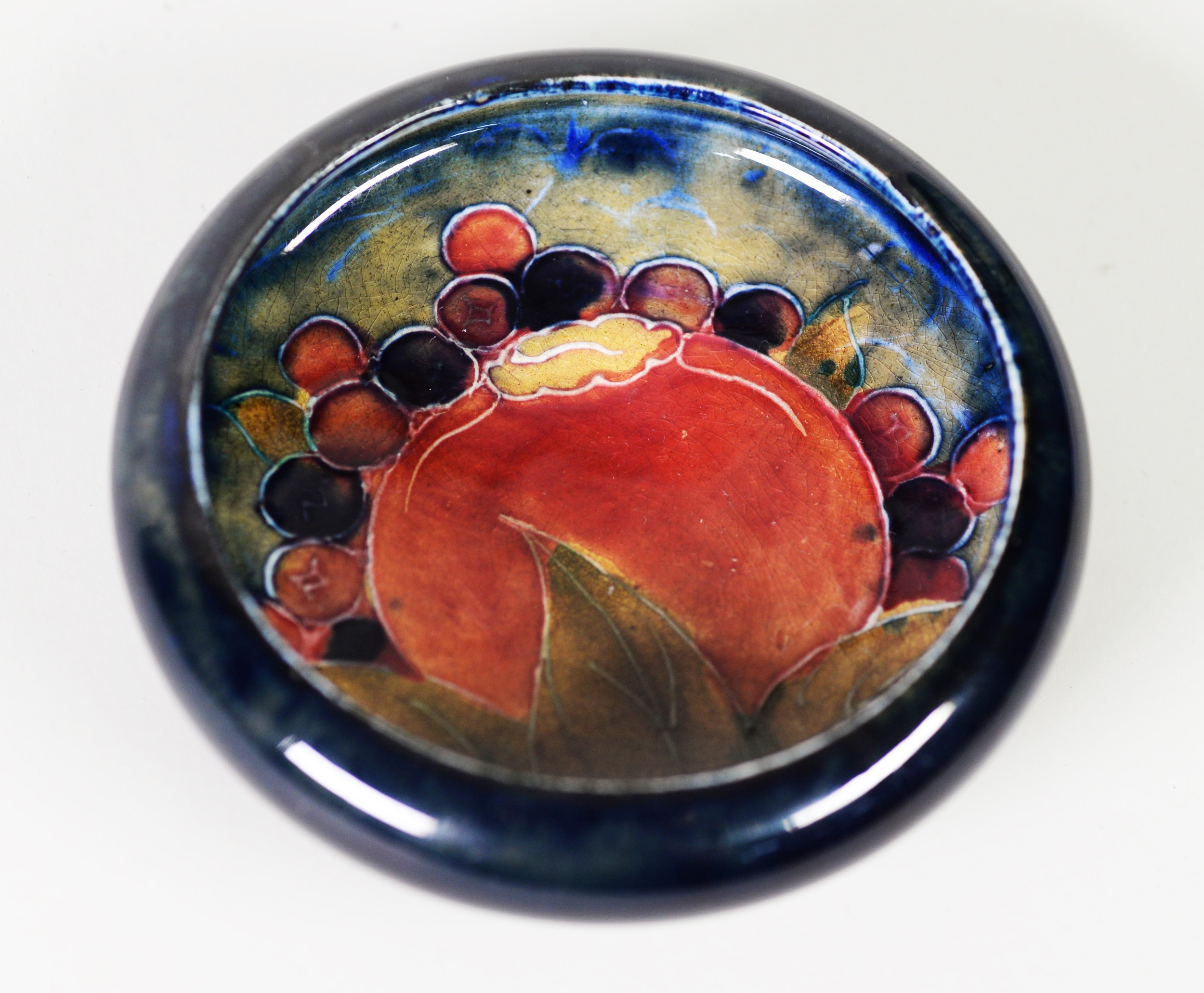 WILLIAM MOORCRCOFT ‘POMEGRANATE’ PATTERN TUBE LINED POTTERY SMALL DISH, painted in tones of red,