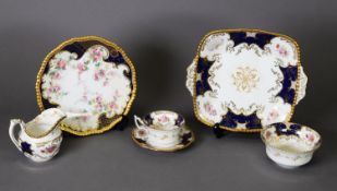 A COLLECTION OF COALPORT TEA AND DINNER WARES, decorated with rose bloom reserves to a royal blue