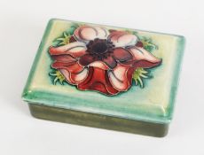 WILLIAM MOORCROFT ANENOME PATTERN TUBE LINED POTTERY BOX AND COVER, of oblong form, decorated in