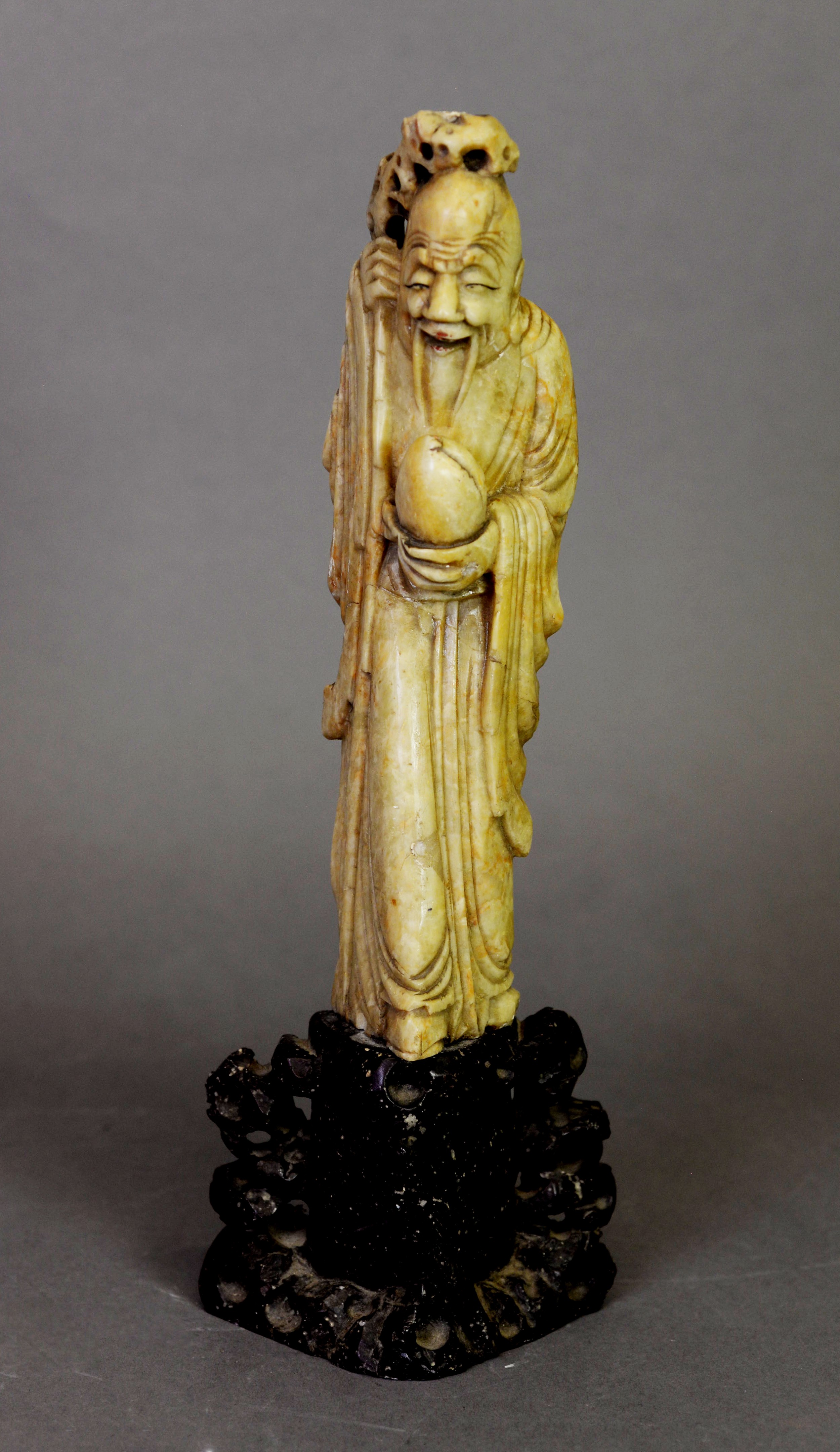 An Chinese fawn soapstone figure of Shoulau, the Chinese immortal of longevity, holding a staff