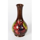 WALTER MOORCROFT ‘HIBISCUS’ PATTERN TUBE LINED POTTERY BOTTLE VASE, of footed form, decorated in