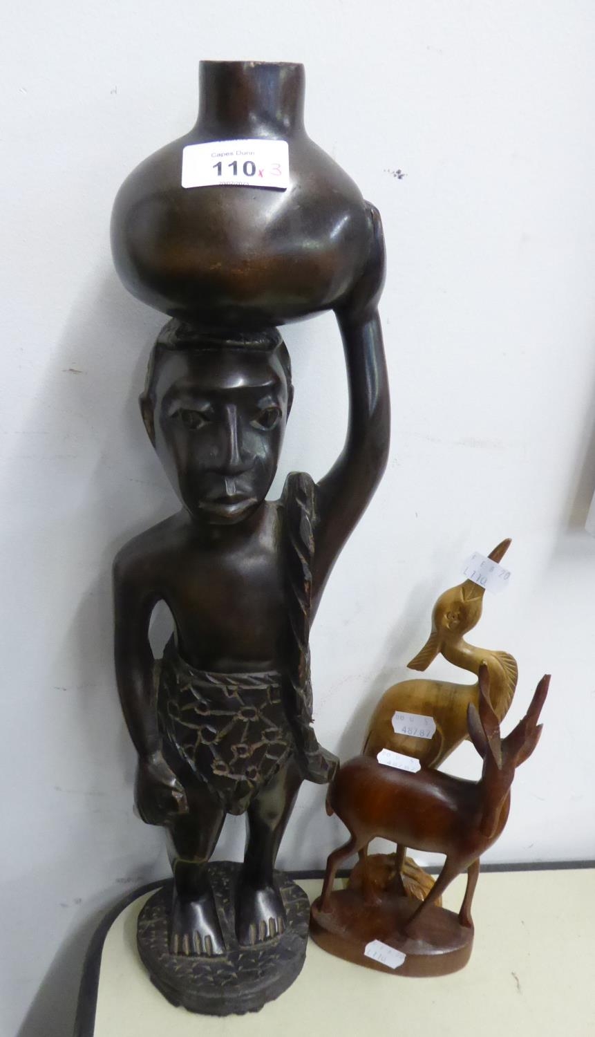 NIGERIAN LARGE CARVED EBONY FIGURE OF A MAN CARRYING A WATER JUG ON HIS HEAD, ON OVAL BASE, 20” HIGH