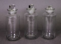 THREE EARLY 20th CENTURY APOTHECARY BOTTLES of cylindrical form, the stoppers with oblong