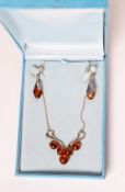 925 MARK SILVER AND GOLDEN AMBER NECKLACE, the scrolled wire pattern front set with five amber beads