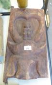 AN ETHNIC CARVED SOFTWOOD DOOR WITH SMALL FIGURES ON THE HEAD OF A BUFFALO, 16” X 9 ½”