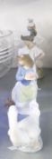 A NAO FIGURE OF A YOUNG GIRL HOLDING HER DRESS, A NAO FIGURE OF A GIRL WITH A PUPPY, ANOTHER OF A