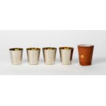 SET OF FOUR GERMAN SILVER PLATED NESTING SMALL TAPERING BEAKERS with gilt interiors, in tan