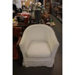 A MODERN TUB SHAPED CHAIR, COVERED IN WHITE FLORAL FABRIC