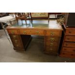 AN OAK DOUBLE PEDESTAL DESK WITH GREEN LEATHER INSET TOP, HAVING TWO BANKS OF FOUR DRAWERS AND A