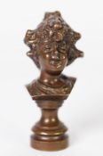 SMALL EARLY 20th CENTURYCAST BRONZE BUST OF A GIRL with curly hair partly in a bun, raised on a