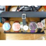 A CYLINDRICAL WATCH HOLDER WITH THREE GENT’S WRISTWATCHES; TWO LADIES QUARTZ WRISTWATCHES AND A