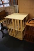 A MODERN BLOND WOOD RECTANGULAR REVOLVING BOOKCASE