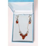 925 MARK SILVER AND GOLDEN AMBER NECKLACE, the scrolled wire pattern front set with five amber beads