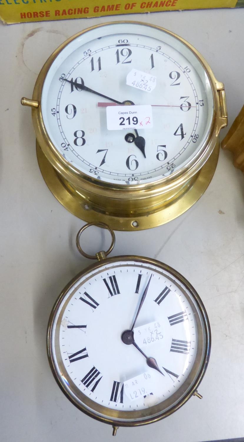 A BRASS SHIP’S TYPE WALL CLOCK, WITH 8 DAYS SPRING DRIVEN MOVEMENT AND A BRAS DRUM CASED MANTEL OR