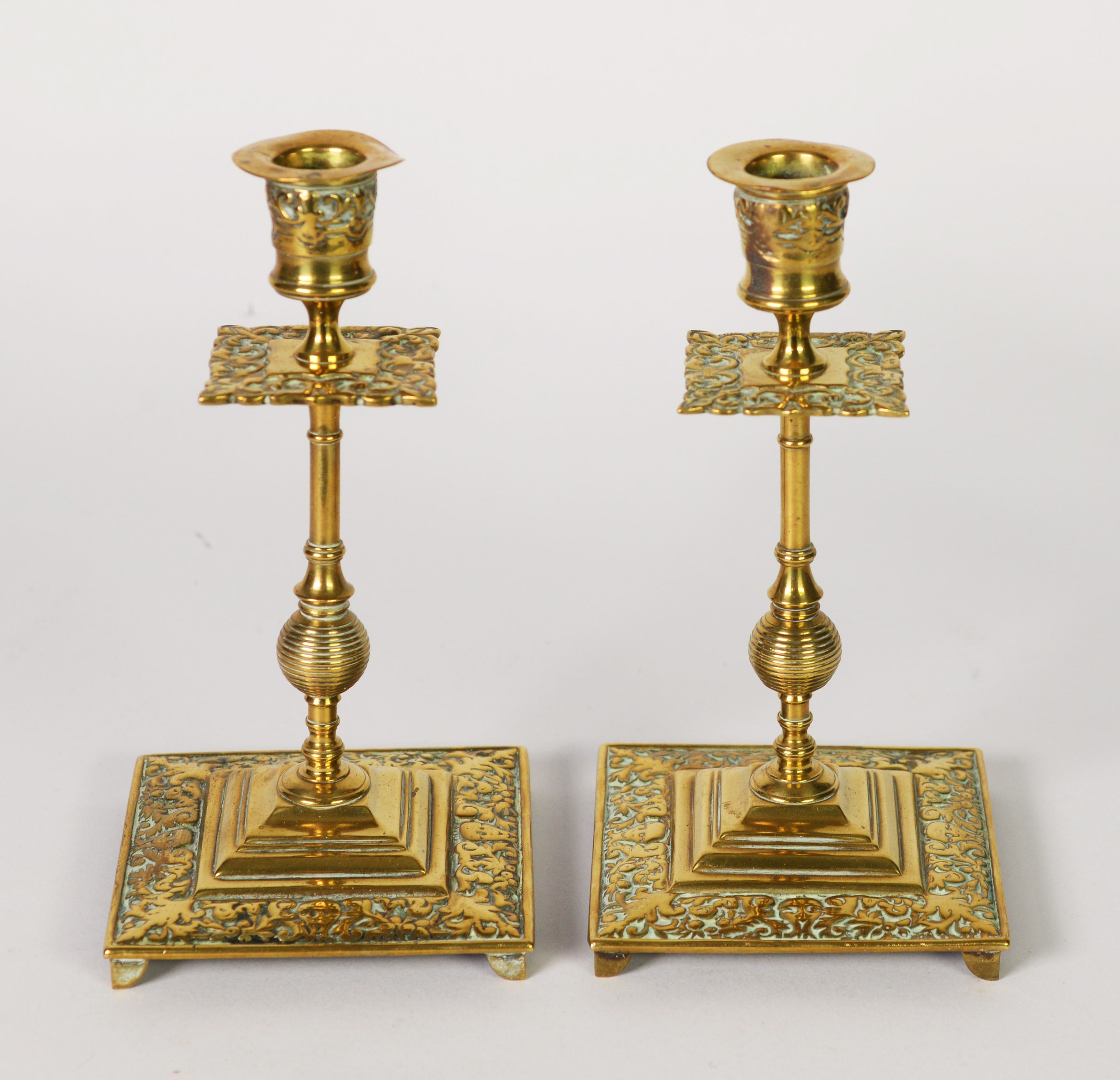 PAIR OF LATE 19th CENTURY ARTS & CRAFTS DESIGN BRASS CANDLESTICKS, with foliate scroll decoration to