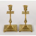 PAIR OF LATE 19th CENTURY ARTS & CRAFTS DESIGN BRASS CANDLESTICKS, with foliate scroll decoration to