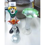 A COLOURED GLASS MODEL OF A CLOWN, COLOURED GLASS TRUMPET VASE AND A CRACKLED GLASS JUG (3)