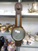 AN EARLY 20TH CENTURY CARVED OAK BANJO SHAPED ANEROID BAROMETER AND THERMOMETER