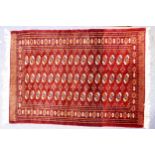FINELY KNOTTED PAKISTAN BOKHARA RUG, with the three rows each of 16 guls, crimson and orange on
