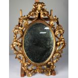 FLORENTINE STYLE CARVED GILTWOOD WALL MIRROR, the oval, mirrored plate within a beaded surround