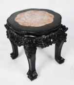 CHINESE CARVED AND EBONISED WOOD AND RED VEINED MARBLE URN STAND, the shaped circular top with