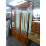 SHERATON STYLE SATINWOOD LARGE DISPLAY CABINET, ENCLOSED BY THREE GLAZED DOORS, ON CUPBOARD BASE