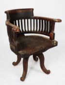 EARLY TWENTIETH CENTURY DARK STAINED FRUITWOOD REVOLVING DESK CHAIR, the shaped top rail above a