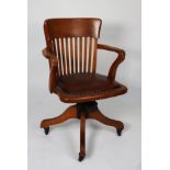 EARLY/ MID TWENTIETH CENTURY OAK RECLINING AND REVOLVING DESK CHAIR, the shaped top rail above a