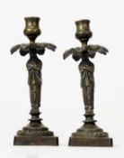 PAIR OF REGENCY STYLE PATINATED BRONZE FIGURAL CANDLESTICKS, each modelled as a standing Egyptian