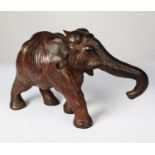 MODERN BROWN LEATHER MODEL OF AN ELEPHANT, modelled with trunk extended, 9” (22.9cm) high