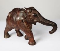 MODERN BROWN LEATHER MODEL OF AN ELEPHANT, modelled with trunk extended, 9” (22.9cm) high
