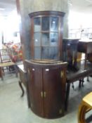 A GEORGE III OAK BOW FRONT CORNER CABINET (A.F.)