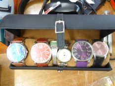 A CYLINDRICAL WATCH HOLDER WITH THREE GENT’S WRISTWATCHES; TWO LADIES QUARTZ WRISTWATCHES AND A