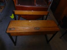 A VINTAGE CHILD'S DOUBLE SEATER OAK DESK, HAVING TWO SLIDE TOP INKWELLS, LIFT-UP DESK TOP AND A