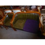 AN OAK FRAMED TWO SEATER SETTEE, COVERED IN GREEN LEATHER WITH LOOSE CUSHIONS AND CURVED BACK AND