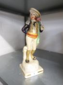 STAFFORDSHIRE POTTERY FIGURE OF A CONQUISTADOR, modelled with a pistol, on a gilt lined square base,