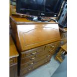 A MAHOGANY BUREAU, WITH SLOPING FALL FRONT OVER FOUR LONG DRAWERS