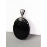 VICTORIAN SILVER COLOURED METAL LARGE OVAL MOURNING LOCKET PENDANT with jet back and front, the