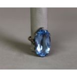 9ct GOLD AND SILVER DRESS RING, with a large oval pale blue paste stone, in a six claw crown