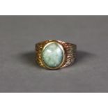 9ct GOLD RING, bark textured and collet set with a cabochon oval green hardstone, maker’s mark HB,