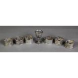 SET OF SIX KELANTAN, MALAYSIAN EMBOSSED SILVER COLOURED METAL NAPKIN RINGS, each of octagonal